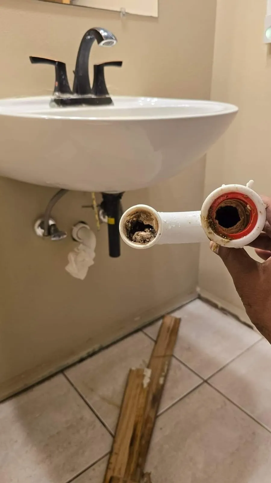 Siphon de lavabo démonté, bouché par des dépôts